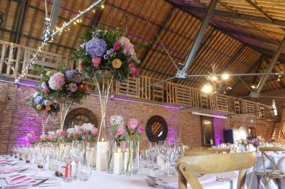 Un couple en tenue de mariage se tient devant un officiant dans un décor festif avec sapins et guirlandes lumineuses.