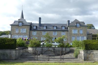 Un couple en tenue de mariage se tient devant un officiant dans un décor festif avec sapins et guirlandes lumineuses.