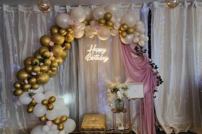 Figurines de mariés sur un gâteau décoré de fleurs bleues, d'une feuille argentée et d'un cœur en arrière-plan.