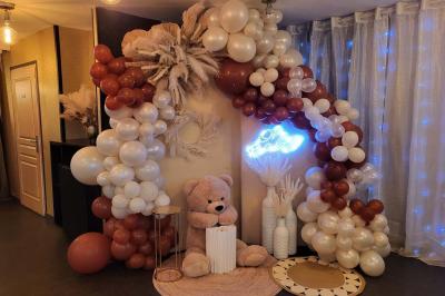 Figurines de mariés sur un gâteau décoré de fleurs bleues, d'une feuille argentée et d'un cœur en arrière-plan.