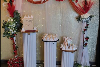 Figurines de mariés sur un gâteau décoré de fleurs bleues, d'une feuille argentée et d'un cœur en arrière-plan.