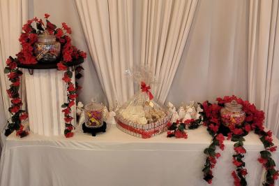 Figurines de mariés sur un gâteau décoré de fleurs bleues, d'une feuille argentée et d'un cœur en arrière-plan.