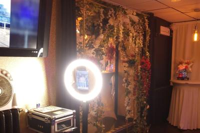 Figurines de mariés sur un gâteau décoré de fleurs bleues, d'une feuille argentée et d'un cœur en arrière-plan.