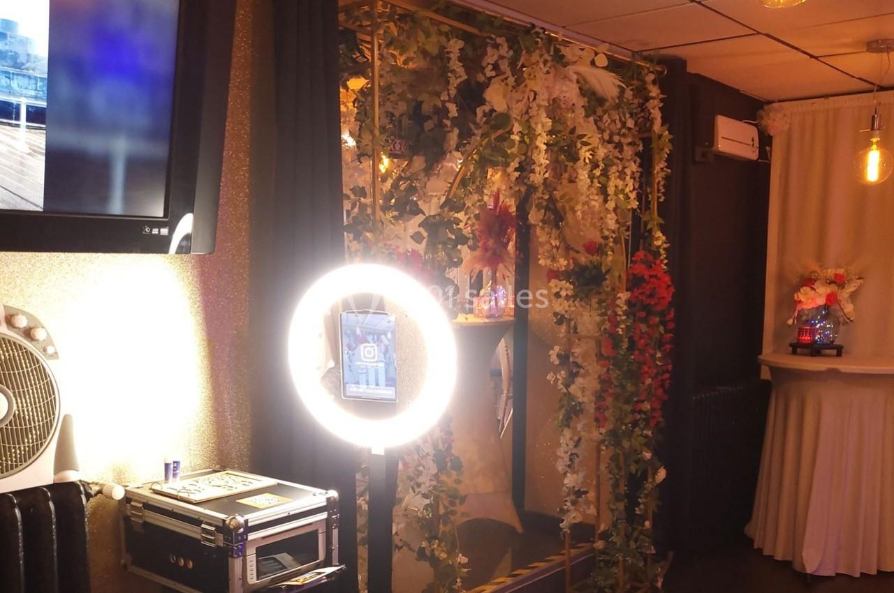 Décor intérieur avec arche ornée de feuillages, éclairage chaleureux et écran mural allumé.