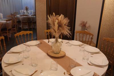 Figurines de mariés sur un gâteau décoré de fleurs bleues, d'une feuille argentée et d'un cœur en arrière-plan.