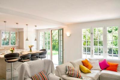 Salle de bain moderne avec lavabo, miroir éclairé, meuble de rangement et douche à paroi vitrée.