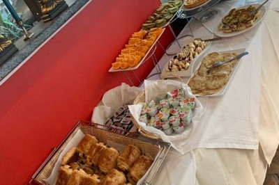 Assiette garnie d'un jarret d'agneau, légumes, pommes de terre rôties, sur une table dressée avec boissons et décorations.