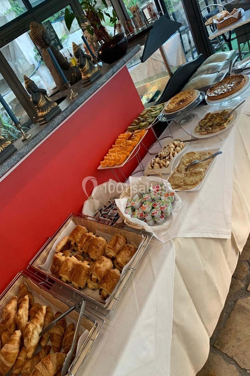 Buffet de petit-déjeuner avec viennoiseries, fruits, tartes, crêpes et divers accompagnements sur une table dressée.