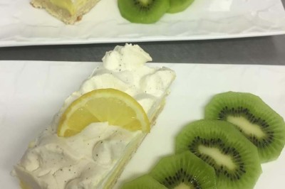 Assiette garnie d'un jarret d'agneau, légumes, pommes de terre rôties, sur une table dressée avec boissons et décorations.