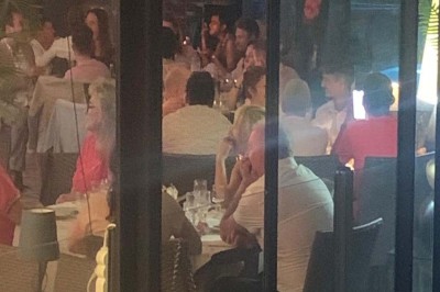 Assiette garnie d'un jarret d'agneau, légumes, pommes de terre rôties, sur une table dressée avec boissons et décorations.