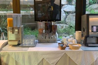 Assiette garnie d'un jarret d'agneau, légumes, pommes de terre rôties, sur une table dressée avec boissons et décorations.