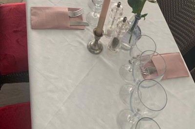 Assiette garnie d'un jarret d'agneau, légumes, pommes de terre rôties, sur une table dressée avec boissons et décorations.