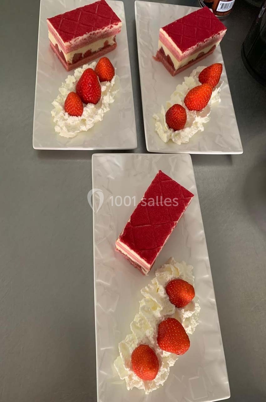 Trois assiettes contenant des desserts à base de mousse rouge, accompagnés de fraises et de crème fouettée.