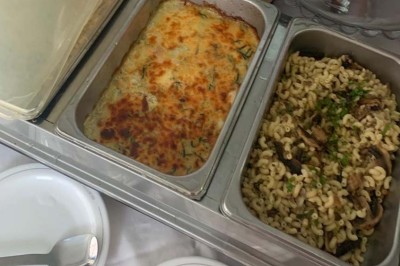 Assiette garnie d'un jarret d'agneau, légumes, pommes de terre rôties, sur une table dressée avec boissons et décorations.