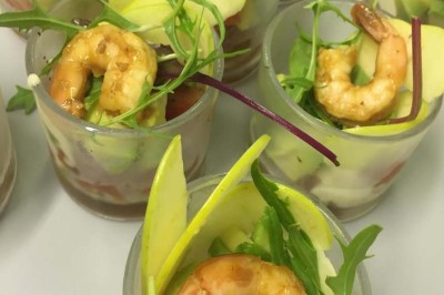 Assiette garnie d'un jarret d'agneau, légumes, pommes de terre rôties, sur une table dressée avec boissons et décorations.
