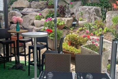 Assiette garnie d'un jarret d'agneau, légumes, pommes de terre rôties, sur une table dressée avec boissons et décorations.