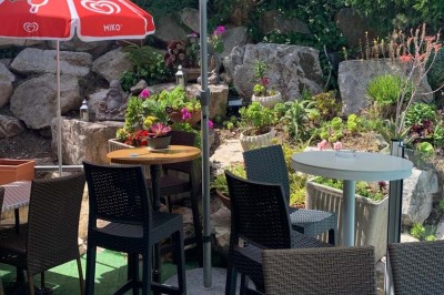 Assiette garnie d'un jarret d'agneau, légumes, pommes de terre rôties, sur une table dressée avec boissons et décorations.