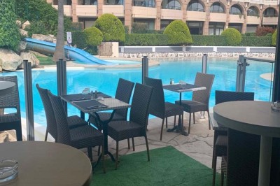 Assiette garnie d'un jarret d'agneau, légumes, pommes de terre rôties, sur une table dressée avec boissons et décorations.