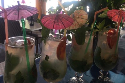Assiette garnie d'un jarret d'agneau, légumes, pommes de terre rôties, sur une table dressée avec boissons et décorations.