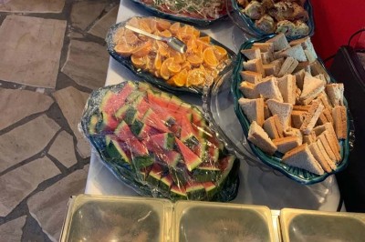 Assiette garnie d'un jarret d'agneau, légumes, pommes de terre rôties, sur une table dressée avec boissons et décorations.