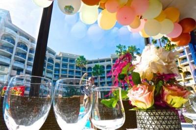 Assiette garnie d'un jarret d'agneau, légumes, pommes de terre rôties, sur une table dressée avec boissons et décorations.