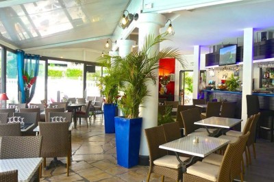 Assiette garnie d'un jarret d'agneau, légumes, pommes de terre rôties, sur une table dressée avec boissons et décorations.