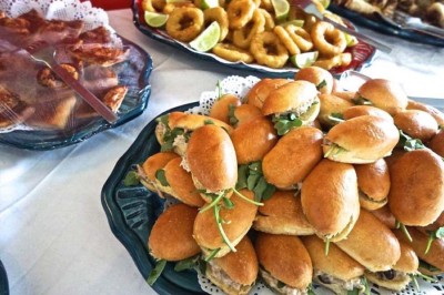 Assiette garnie d'un jarret d'agneau, légumes, pommes de terre rôties, sur une table dressée avec boissons et décorations.