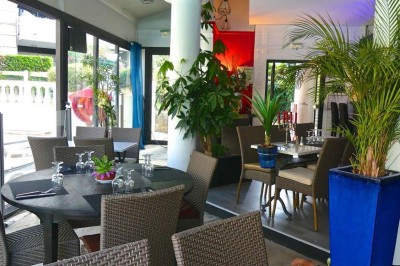 Assiette garnie d'un jarret d'agneau, légumes, pommes de terre rôties, sur une table dressée avec boissons et décorations.