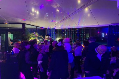 Assiette garnie d'un jarret d'agneau, légumes, pommes de terre rôties, sur une table dressée avec boissons et décorations.