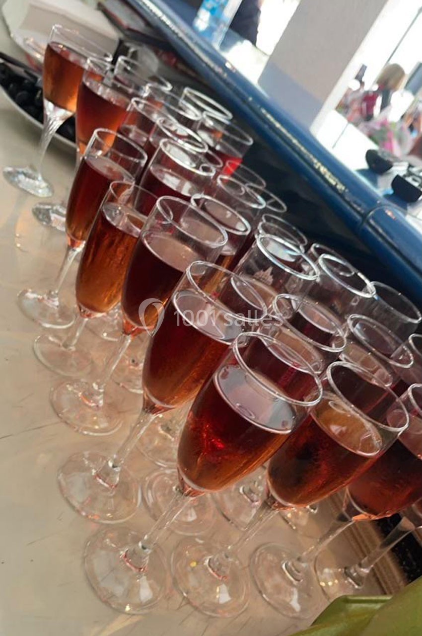 Verres de vin rosé alignés sur une table, prêts à être servis lors d'un événement ou d'une réception.