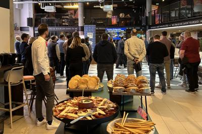 Lavabo moderne avec miroir, distributeur de savon mural et carrelage beige dans une salle de bain.
