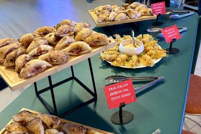 Lavabo moderne avec miroir, distributeur de savon mural et carrelage beige dans une salle de bain.
