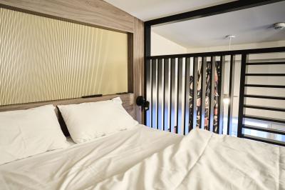 Lavabo moderne avec miroir, distributeur de savon mural et carrelage beige dans une salle de bain.