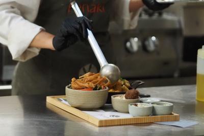 Lavabo moderne avec miroir, distributeur de savon mural et carrelage beige dans une salle de bain.