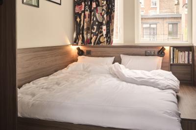 Lits superposés en bois avec rideaux jaunes dans une chambre lumineuse, échelle et fenêtres sur le côté.