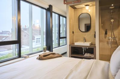 Lits superposés en bois avec rideaux jaunes dans une chambre lumineuse, échelle et fenêtres sur le côté.