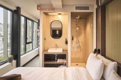 Lits superposés en bois avec rideaux jaunes dans une chambre lumineuse, échelle et fenêtres sur le côté.