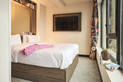 Lits superposés en bois avec rideaux jaunes dans une chambre lumineuse, échelle et fenêtres sur le côté.