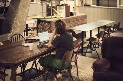 Lits superposés en bois avec rideaux jaunes dans une chambre lumineuse, échelle et fenêtres sur le côté.