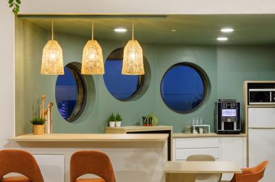 Deux lavabos blancs avec robinets modernes sur un plan noir, devant un mur carrelé à motifs géométriques.