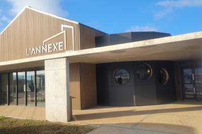 Deux lavabos blancs avec robinets modernes sur un plan noir, devant un mur carrelé à motifs géométriques.