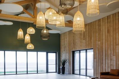 Deux lavabos blancs avec robinets modernes sur un plan noir, devant un mur carrelé à motifs géométriques.