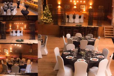 Salle élégante avec parquet, comptoir noir, lustre central et grandes fenêtres encadrées de rideaux.