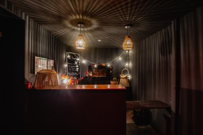 Couloir sombre avec éclairage violet, menant à un lavabo éclairé par un miroir rond lumineux.