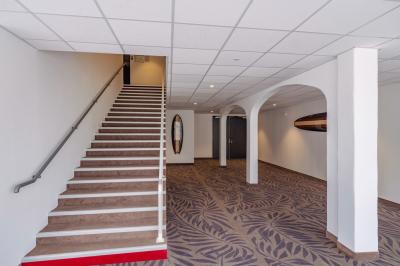 Vue aérienne d'une plage bordée de falaises avec des maisons et un parking à proximité, dans un paysage côtier.
