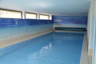 Deux femmes souriantes posent devant une voiture grise marquée ’France Bleu’, stationnée devant un bâtiment en pierre.