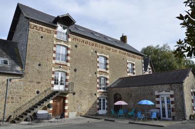 Deux femmes souriantes posent devant une voiture grise marquée ’France Bleu’, stationnée devant un bâtiment en pierre.