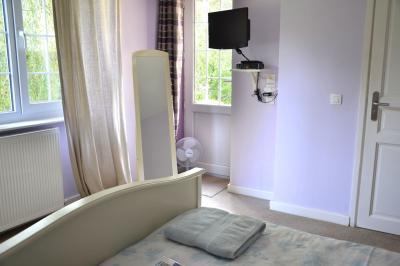 Deux femmes souriantes posent devant une voiture grise marquée ’France Bleu’, stationnée devant un bâtiment en pierre.