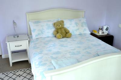 Deux femmes souriantes posent devant une voiture grise marquée ’France Bleu’, stationnée devant un bâtiment en pierre.