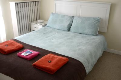 Deux femmes souriantes posent devant une voiture grise marquée ’France Bleu’, stationnée devant un bâtiment en pierre.